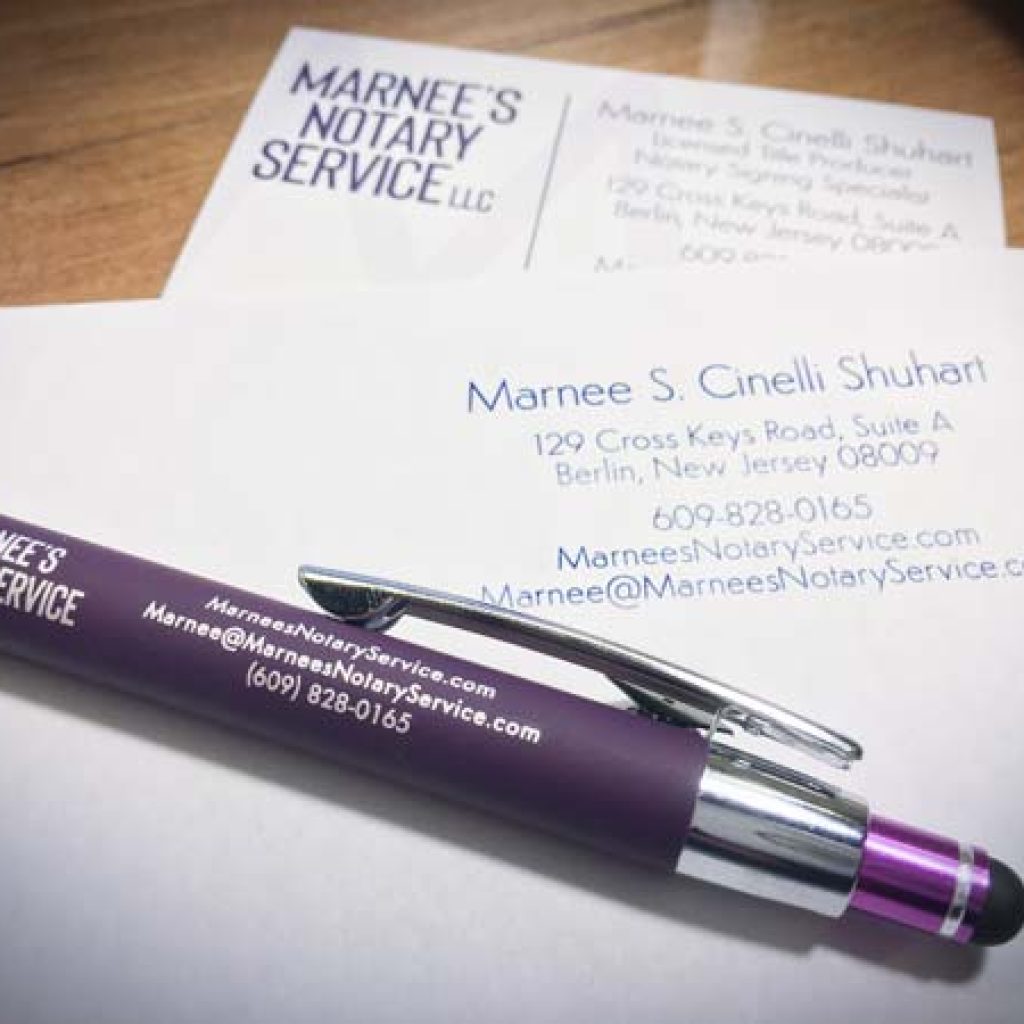 Photo of a pen, business card, and letterhead with Marnee's Notary Service contact information on them